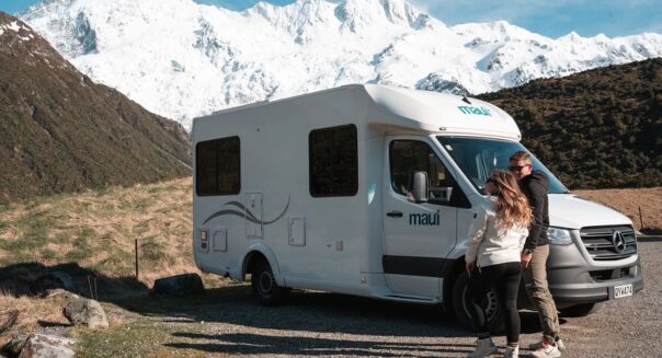 Stel loopt naar Maui Cascade toe in de buurt van Dunedin met besneeuwde berg op de achtergrond