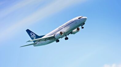 Airplane, flying and blue sky for travel, holiday and vacation or immigration opportunity with New Zealand airline. Plane, aircraft and transportation in air or outdoors for an international flight