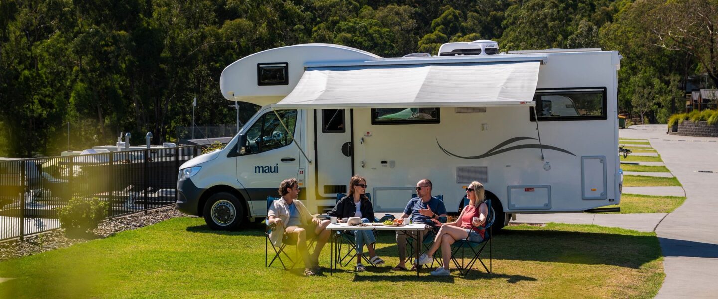 Twee koppels zitten voor de Maui River camper op een camping in de Yarra Valley
