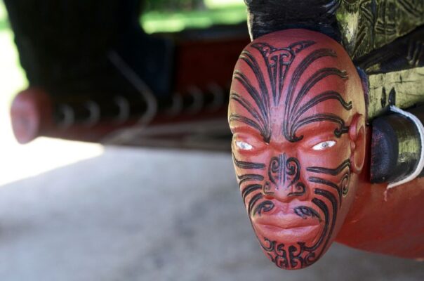 Houtdecoratie van een hoofd op de punt van een Maori kano