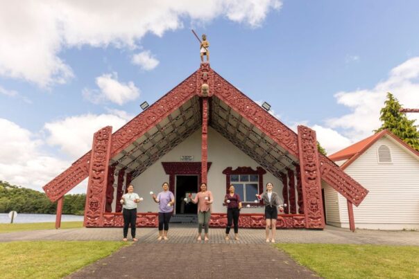 Marae gebouw van de Maoi met 5 mensen ervoor