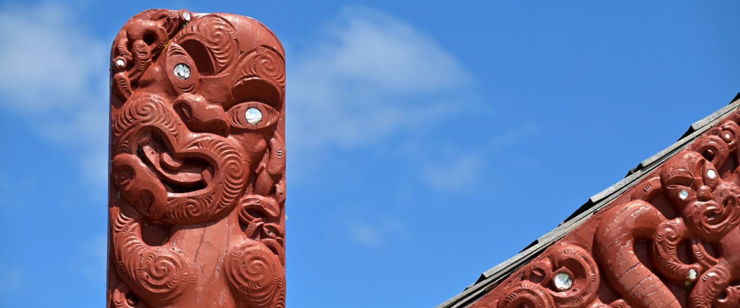 Maori houtsnijwerk tegen een blauwe lucht