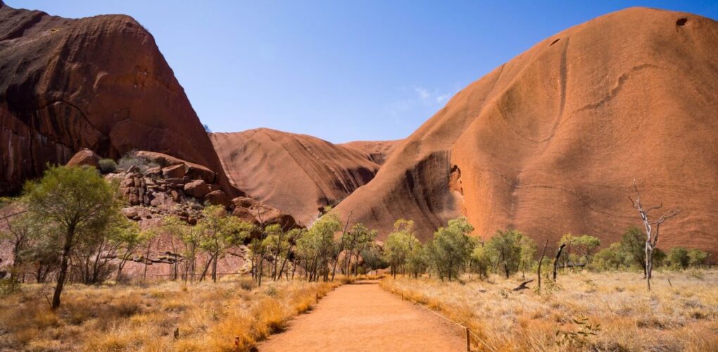 Zicht op Uluru-Ayers-Rock in het Red Centre vanaf een gravelweg