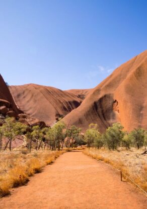Zicht op Uluru-Ayers-Rock in het Red Centre vanaf een gravelweg
