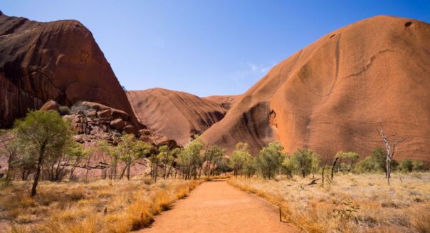 Zicht op Uluru-Ayers-Rock in het Red Centre vanaf een gravelweg
