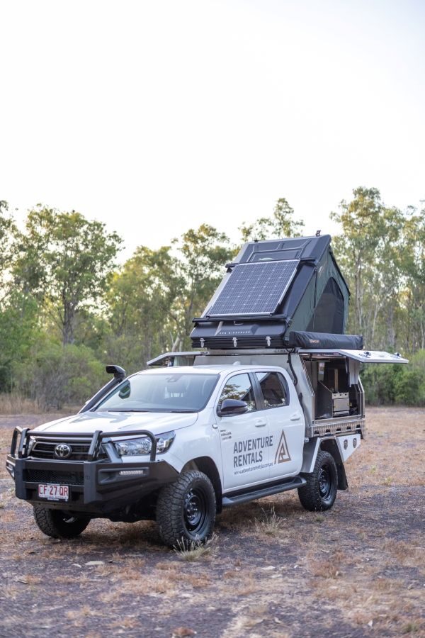 Adventure Rentals Toyota Hilux 4WD met enkele Daktent staat geparkeerd met de tent open en het zonnepaneel zichtbaar